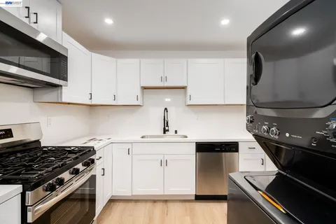 a kitchen with stainless steel appliances a sink dishwasher stove top oven and cabinets