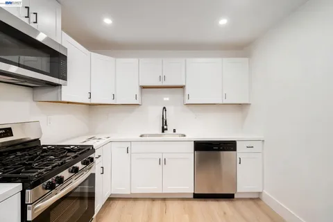 a kitchen with stainless steel appliances granite countertop a sink stove top oven and cabinets