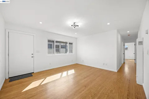 a view of empty room with wooden floor and window