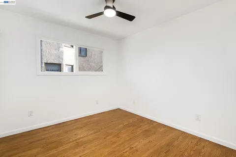 an empty room with a window and wooden floor
