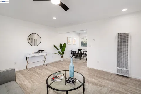 a living room with furniture a clock and wooden floor