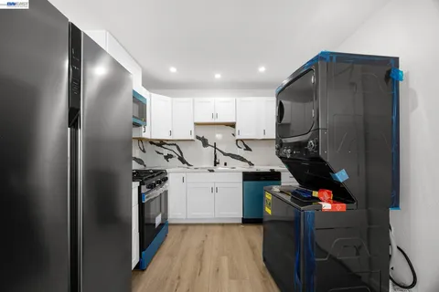 a kitchen with refrigerator and white cabinets