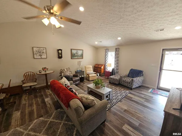 a living room with furniture a chandelier and a dining table