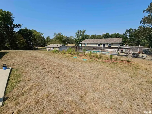 a swimming pool with outdoor seating and yard