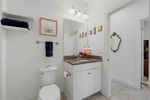 a bathroom with a granite countertop sink a toilet and a mirror