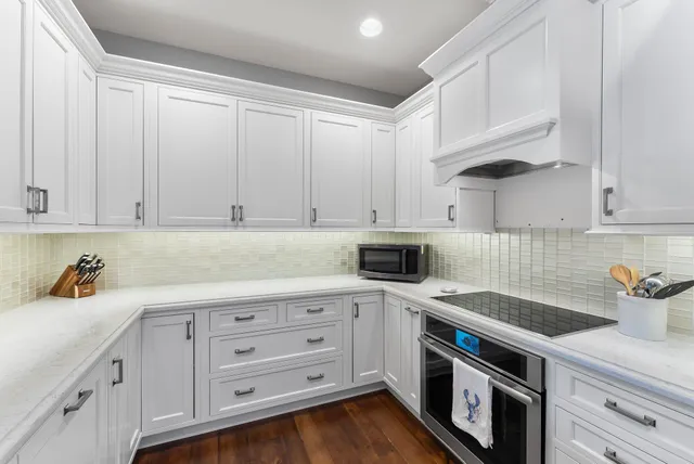 a kitchen with white cabinets and white appliances