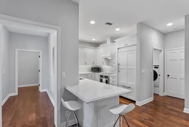 a kitchen with white cabinets and refrigerator