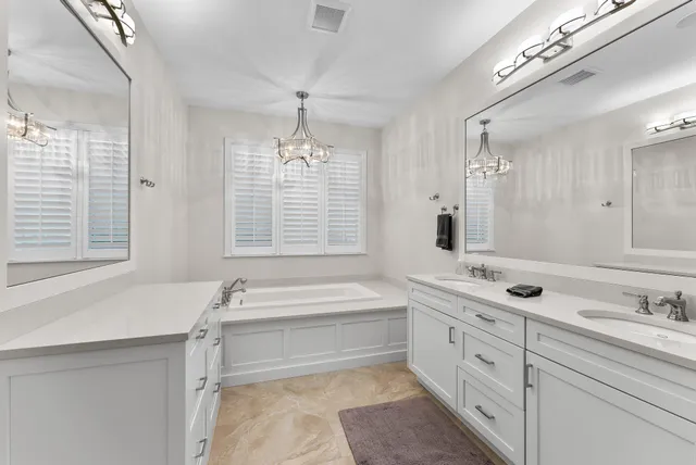 a bath room with a sink vanity tub and shower