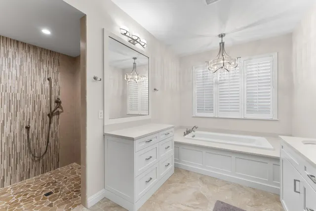 a spacious bathroom with a double vanity sink a mirror and a bathtub