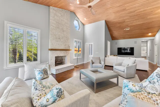 a living room with furniture fireplace and a large window