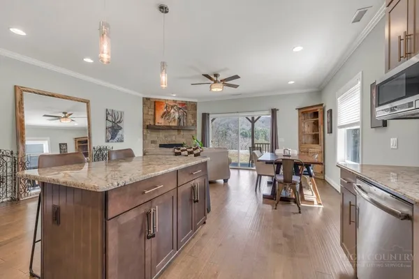 a kitchen with granite countertop wooden cabinets and a stove top oven
