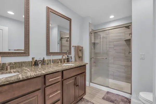 a bathroom with a granite countertop toilet sink and mirror