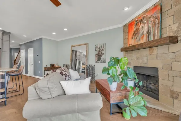 a living room with furniture a fireplace and a kitchen view