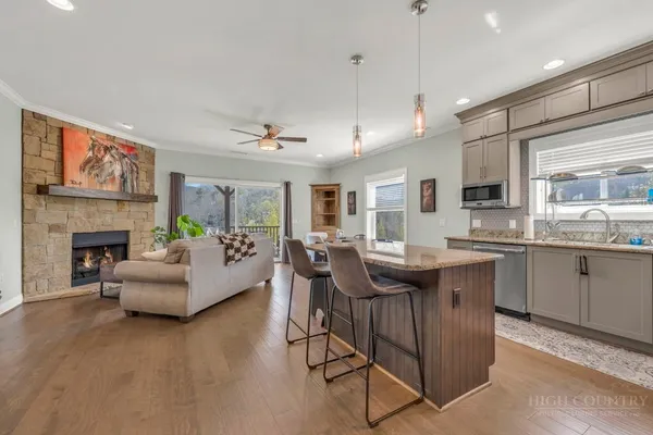 a kitchen with stainless steel appliances a refrigerator a stove a sink a dining table and chairs