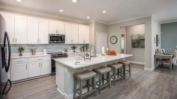a kitchen with white cabinets and stainless steel appliances