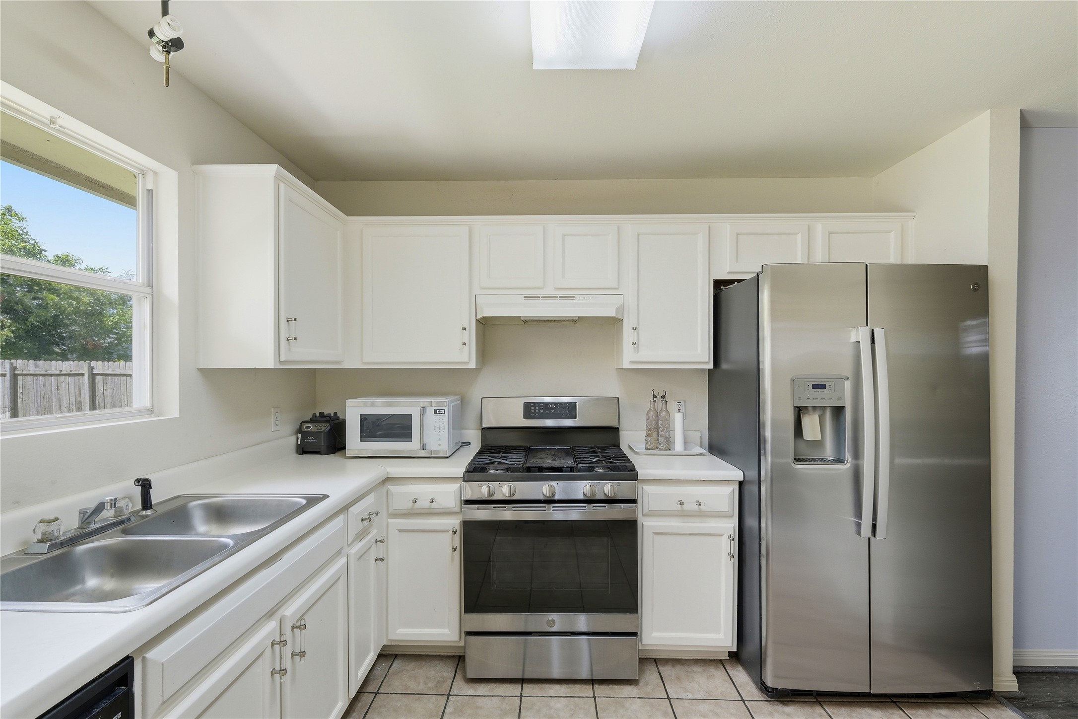 310 Raintree Drive Georgetown, TX 78626 - Photo 6 of 12 White cabinetry and stainless steel appliances complete this compact and efficient kitchen layout.