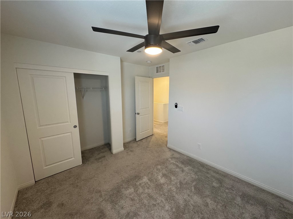2821 Alcobaca Street Henderson, NV 89044 - Photo 16 of 24 A well-proportioned bedroom with plush carpeting, featuring a modern ceiling fan and ample closet space.