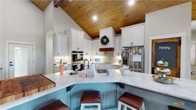 a living room with stainless steel appliances kitchen island granite countertop furniture and a wooden floor
