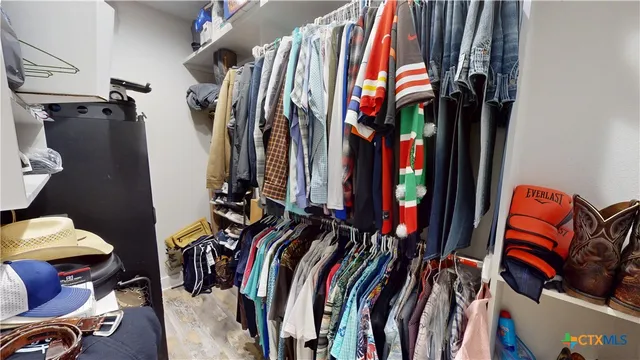 a view of walk in closet with clothes and shoes