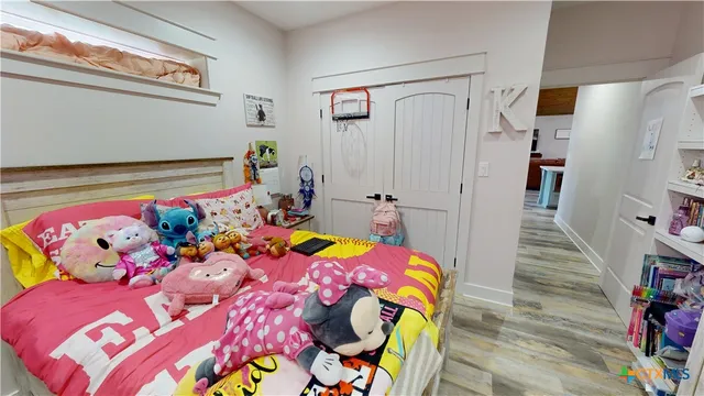 a bedroom with a bed and a wooden floor
