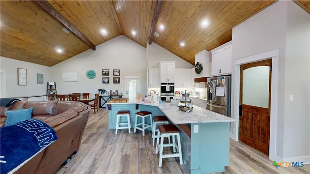 a living room with lots of furniture and kitchen view