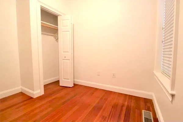 an empty room with wooden floor and a window