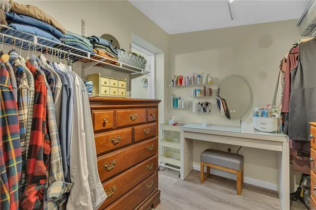 a view of walk in closet with clothes and shoes