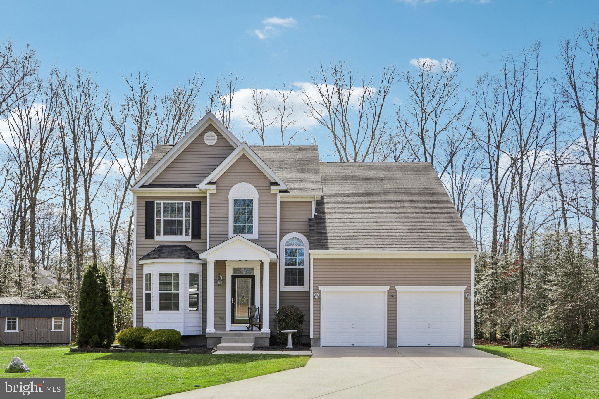 a front view of a house with a yard and trees