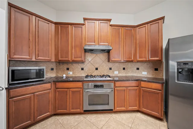 a kitchen with stainless steel appliances granite countertop a stove a sink dishwasher and a microwave
