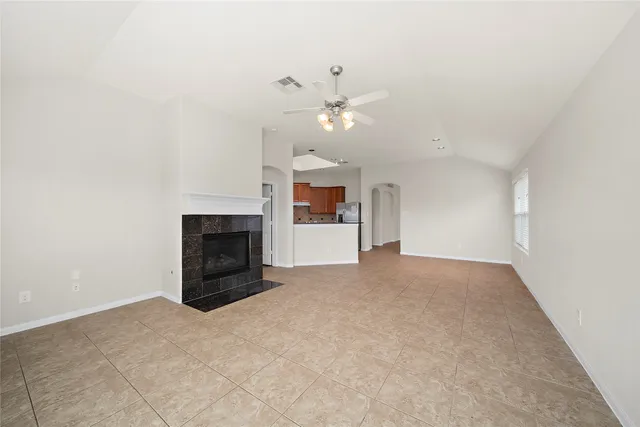 an empty room with a fireplace and fan