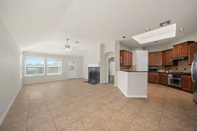 a view of a kitchen with furniture and stainless steel appliances