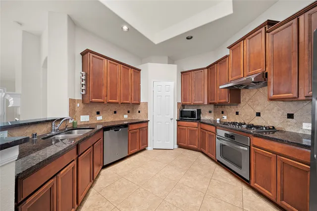 a kitchen with stainless steel appliances granite countertop a stove sink and cabinets