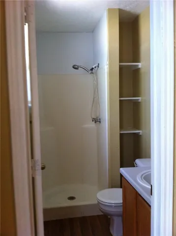 a bathroom with a toilet and a shower