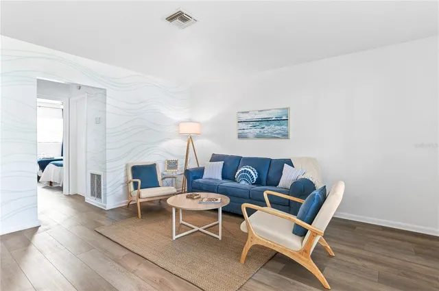 a living room with furniture a flat screen tv and a window