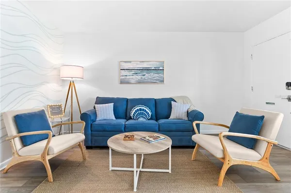 a living room with furniture a flat screen tv and a floor to ceiling window