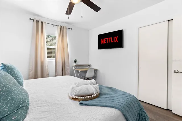 a living room with furniture a flat screen tv and a window
