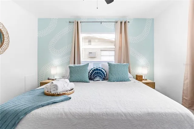 a living room with furniture a flat screen tv and a floor to ceiling window