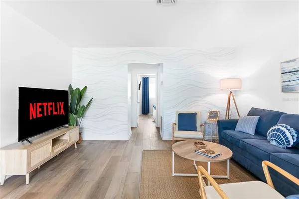 a living room with furniture and a wooden floor