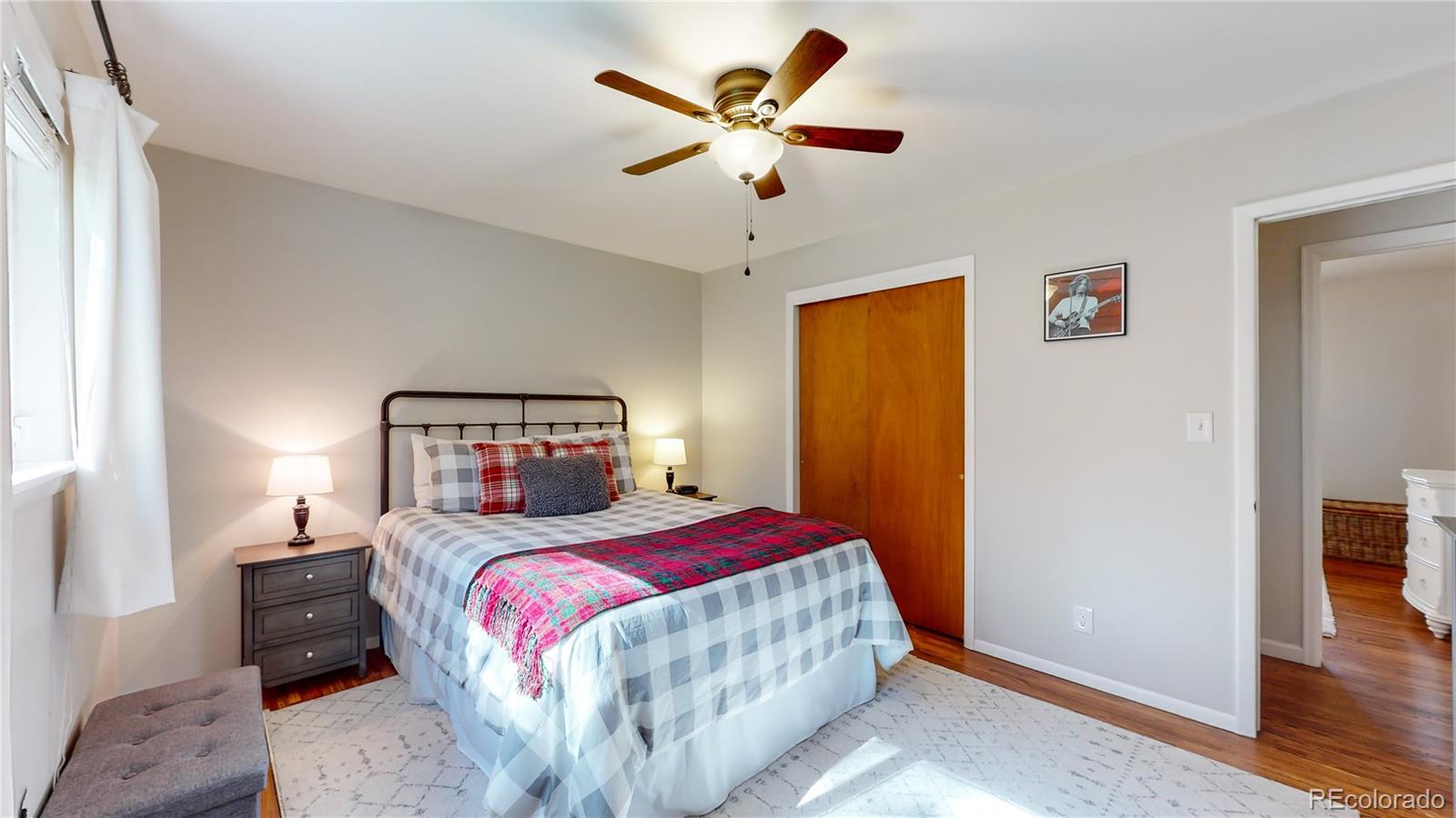 8020 Cyprus Road Colorado Springs, CO 80908 - Photo 21 of 42 a bedroom with a large bed and a ceiling fan