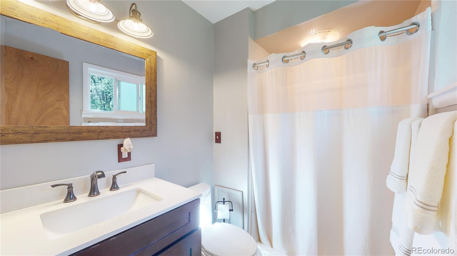 8020 Cyprus Road Colorado Springs, CO 80908 - Photo 22 of 42 a bathroom with a sink vanity mirror and tub