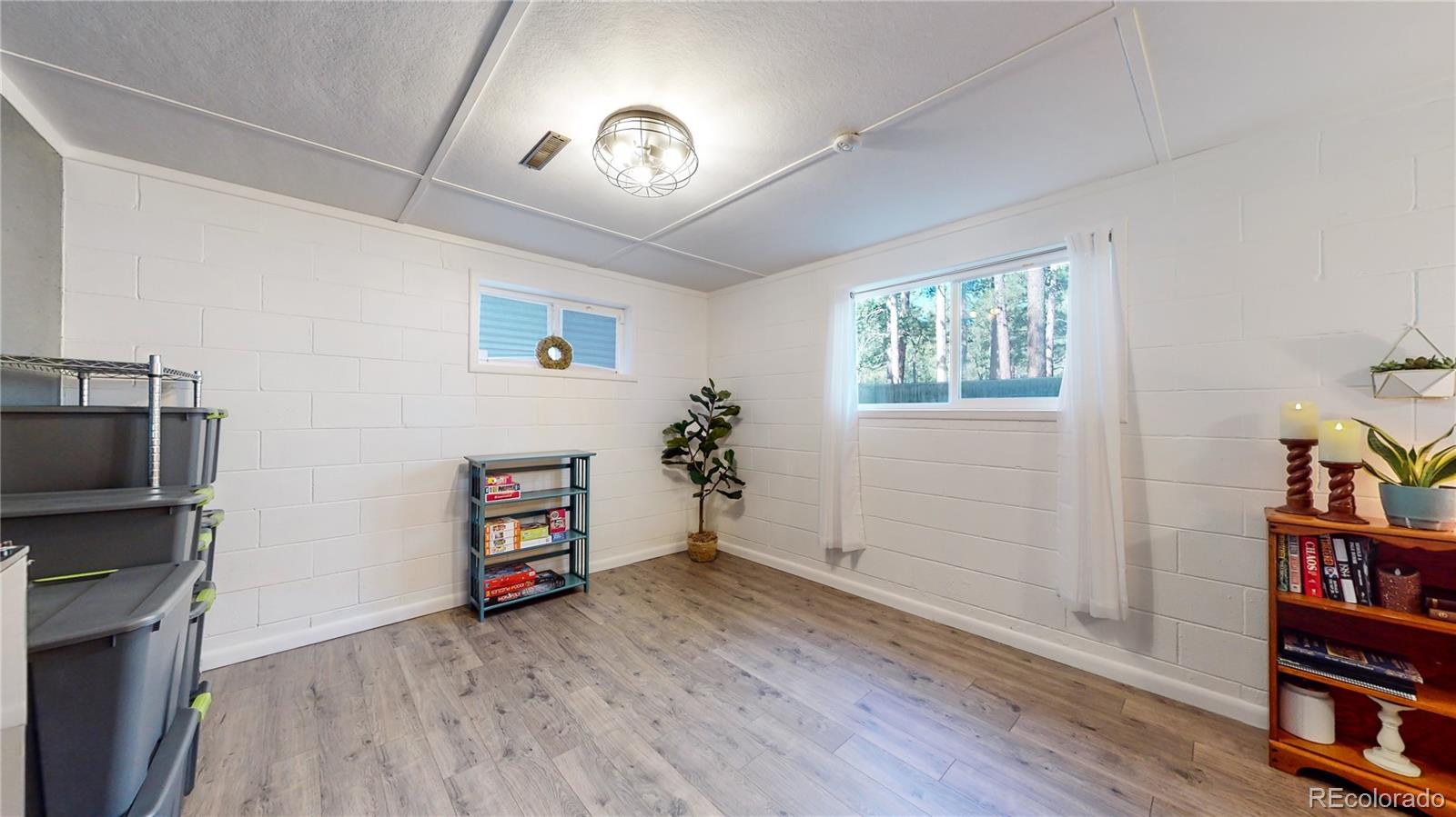 8020 Cyprus Road Colorado Springs, CO 80908 - Photo 26 of 42 a view of an empty room with a window and wooden floor