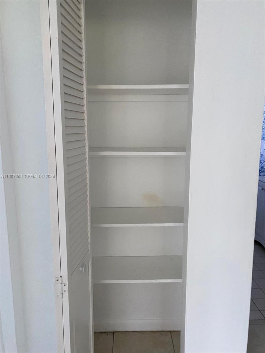1755 Northeast 116th Road, Unit 8 North Miami, FL 33181 - Photo 11 of 23 a view of walk in closet with empty racks