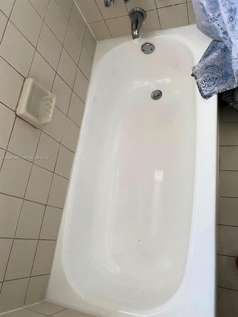 1755 Northeast 116th Road, Unit 8 North Miami, FL 33181 - Photo 17 of 23 a bathroom with a white bathtub