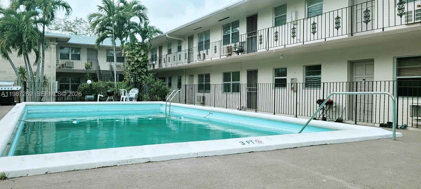 1755 Northeast 116th Road, Unit 8 North Miami, FL 33181 - Photo 20 of 23 a swimming pool with patio outdoor seating and yard