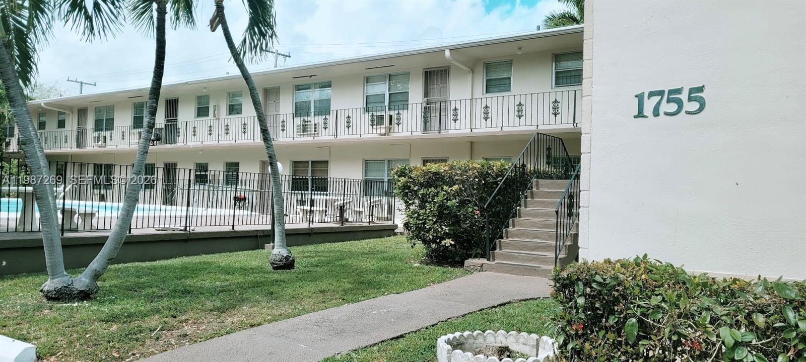 1755 Northeast 116th Road, Unit 8 North Miami, FL 33181 - Photo 22 of 23 a front view of a house with a garden