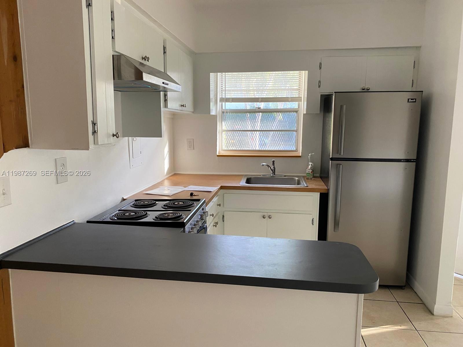 1755 Northeast 116th Road, Unit 8 North Miami, FL 33181 - Photo 6 of 23 a kitchen with a refrigerator and a sink