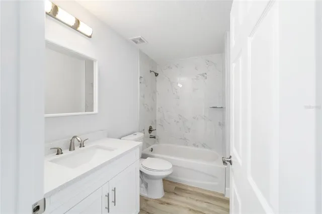 a bathroom with a granite countertop sink toilet a shower and a mirror