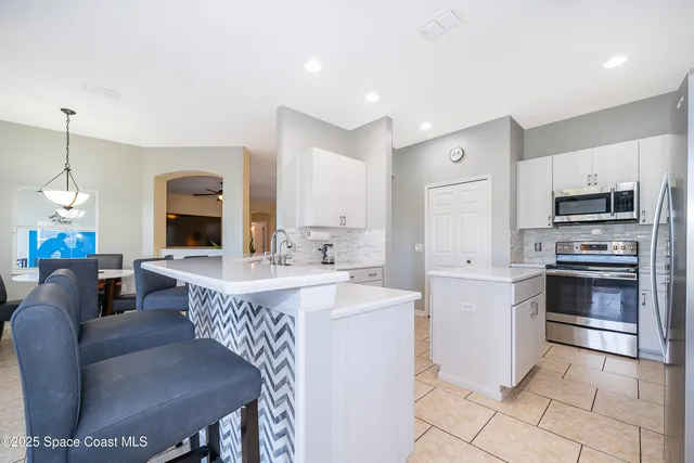 a large kitchen with kitchen island a table and chairs