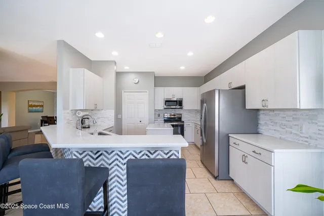 a large kitchen with kitchen island a sink stainless steel appliances and cabinets