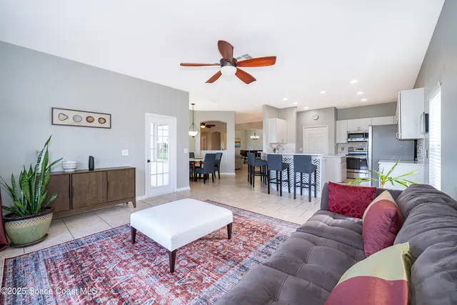 a living room with furniture a dining table and a potted plant